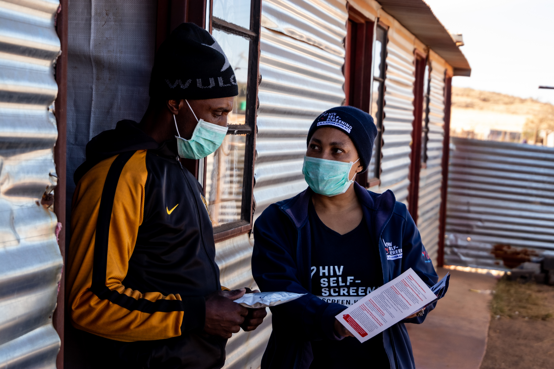 hiv-testing-unitaid-zambia Community outreach worker sharing information while delivering an HIV self-test kit in Johannesburg, South Africa
