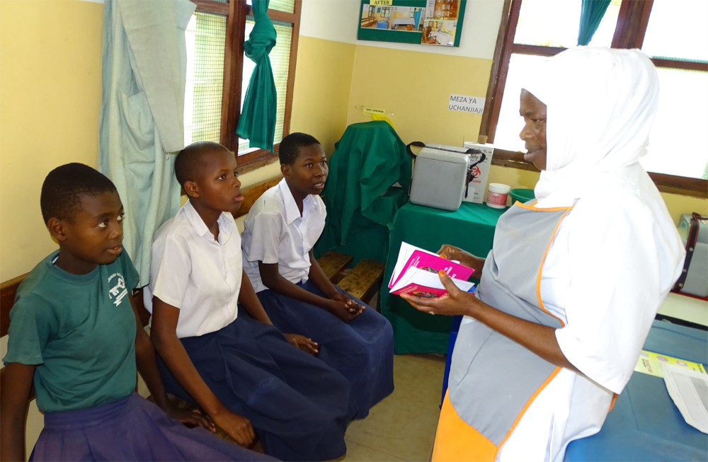 protecting-girls in Tanzania Health care worker interacting with Tanzanian girls before vaccination
