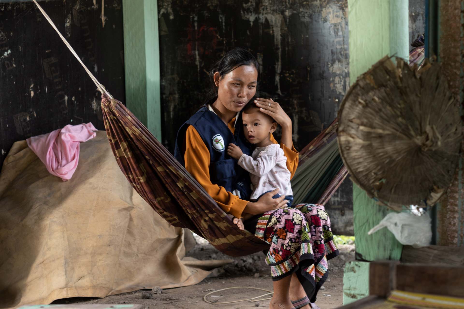 20221025_Attapeu-194 A WHO staff comforts a child while sitting in a hammock